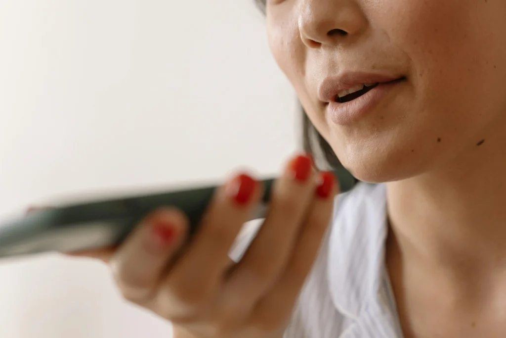 A woman using voice assistant (Siri or Alexa) on their phone